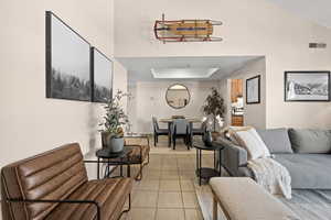 Living room with light tile patterned flooring and a tray ceiling