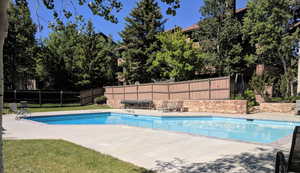 View of swimming pool with a patio and a fenced backyard