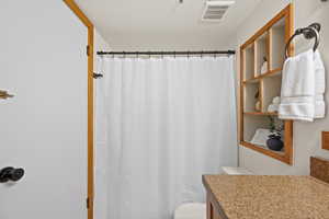 Bathroom with a shower with curtain and vanity