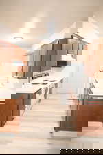 Kitchen with white appliances, light countertops, brown cabinetry, and light wood-style floors