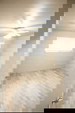 Empty room with a ceiling fan and light wood-style flooring