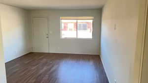 Spare room with dark wood finished floors and baseboards