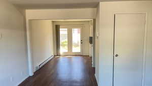 Foyer entrance with a baseboard radiator and dark wood-type flooring