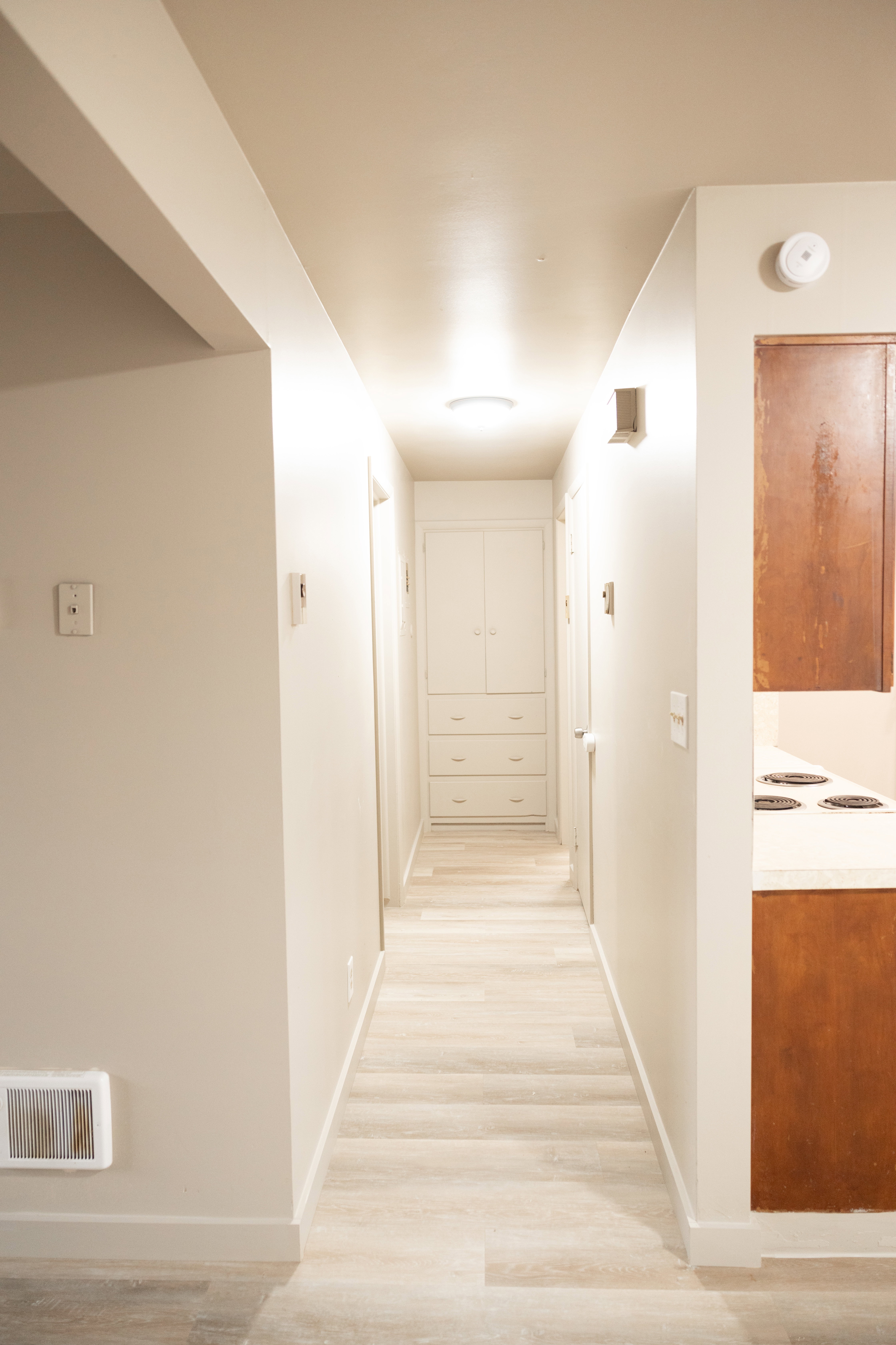Hallway with light wood-type flooring and baseboards