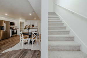 Staircase featuring recessed lighting and wood finished floors
