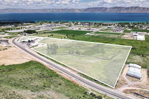 Aerial view of property and surrounding area with a water and mountain view and property parcel outlined