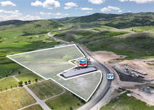 Aerial view of property and surrounding area featuring property parcel outlined and a mountain backdrop