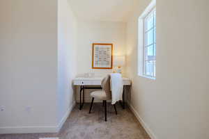 Office space with light carpet and baseboards