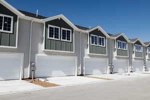 View of front of home with board and batten siding, concrete driveway, and a garage
