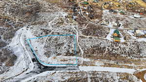 Snowy aerial view with property parcel outlined and a residential view