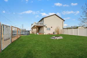 Rear view of property featuring a fenced backyard, an outdoor fire pit, and a deck