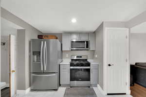 Kitchen featuring appliances with stainless steel finishes, gray cabinets, and recessed lighting