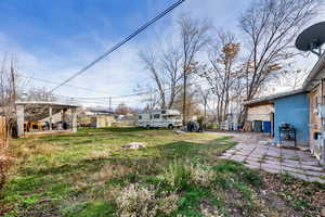View of green lawn featuring a patio