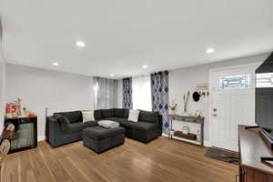 Living area with light wood-style floors and recessed lighting