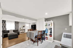 Dining area featuring light marble finish floors and recessed lighting