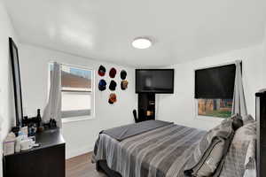 Bedroom with wood finished floors and baseboards