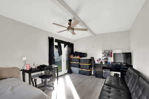 Bedroom with beamed ceiling, access to exterior, light wood-style flooring, a ceiling fan, and an office area