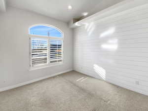 Unfurnished room with carpet flooring and wood walls