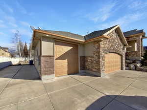 View of front of house featuring a garage, a shingled roof, stucco siding, and driveway