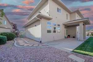 Back of property with stucco siding and a patio area