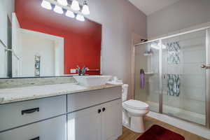 Full bath featuring vanity, a stall shower, and light wood-type flooring