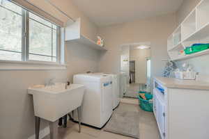 Laundry room featuring washing machine and clothes dryer and light tile patterned floors