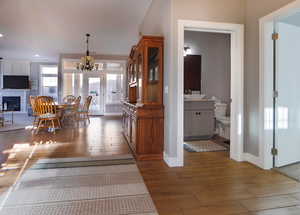 Dining space with hardwood / wood-style flooring, a chandelier, a fireplace, and recessed lighting