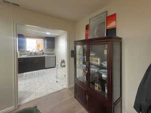 Corridor with a sink and light wood finished floors