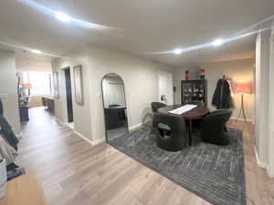 Dining space featuring arched walkways and light wood-style flooring