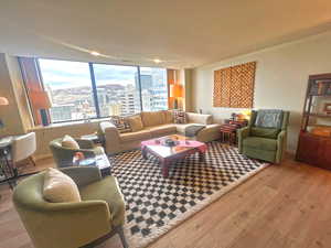 Living room with hardwood / wood-style floors, ornamental molding, and a view of city