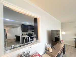 Living room featuring crown molding and light wood-style floors