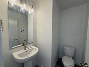 Bathroom with toilet and wood finished floors