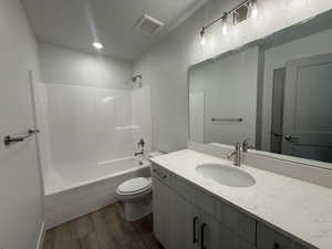 Full bath featuring bathtub / shower combination, vanity, and dark wood-style floors