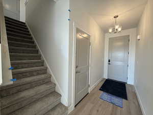 Entrance foyer featuring stairs, wood finished floors, and a chandelier