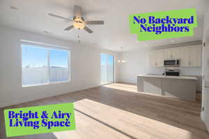 Unfurnished living room featuring light wood finished floors, recessed lighting, ceiling fan, and a chandelier