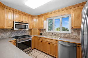 Kitchen with newer stainless steel appliances, gas stove, built-in microwave & valley view