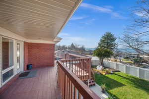 View of west facing wooden balcony overlooking backyard and valley