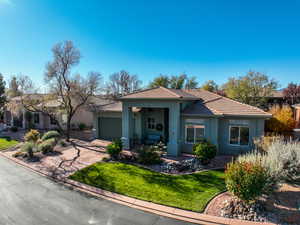 View of front of property featuring stucco siding, a front yard, a garage, a porch, and driveway