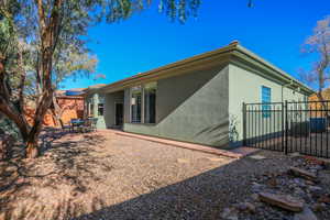 Back of property with stucco siding, a patio, and a gate