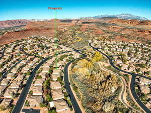 Aerial view of property's location with a mountain backdrop and nearby suburban area