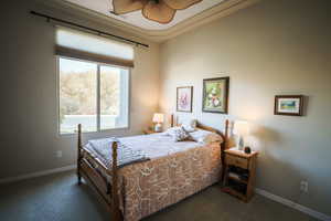Carpeted bedroom with baseboards and ceiling fan