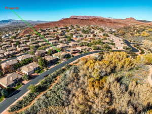 Aerial view of property's location featuring a mountainous background and nearby suburban area