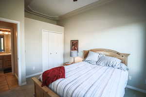 Bedroom featuring dark carpet, a closet, ceiling fan, and connected bathroom