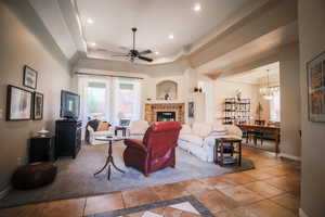 Living area featuring a tray ceiling, a chandelier, a ceiling fan, tile patterned flooring, and recessed lighting