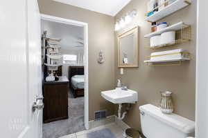 Ensuite bathroom featuring light tile patterned floors and light colored carpet