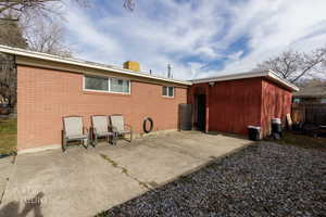 Rear view of house featuring a patio area and brick siding
