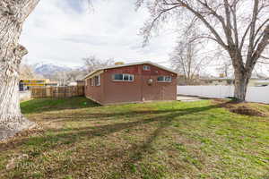 Fenced backyard featuring an outdoor structure and a patio area