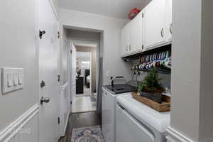 Washroom featuring cabinet space, separate washer and dryer, and dark wood-style flooring