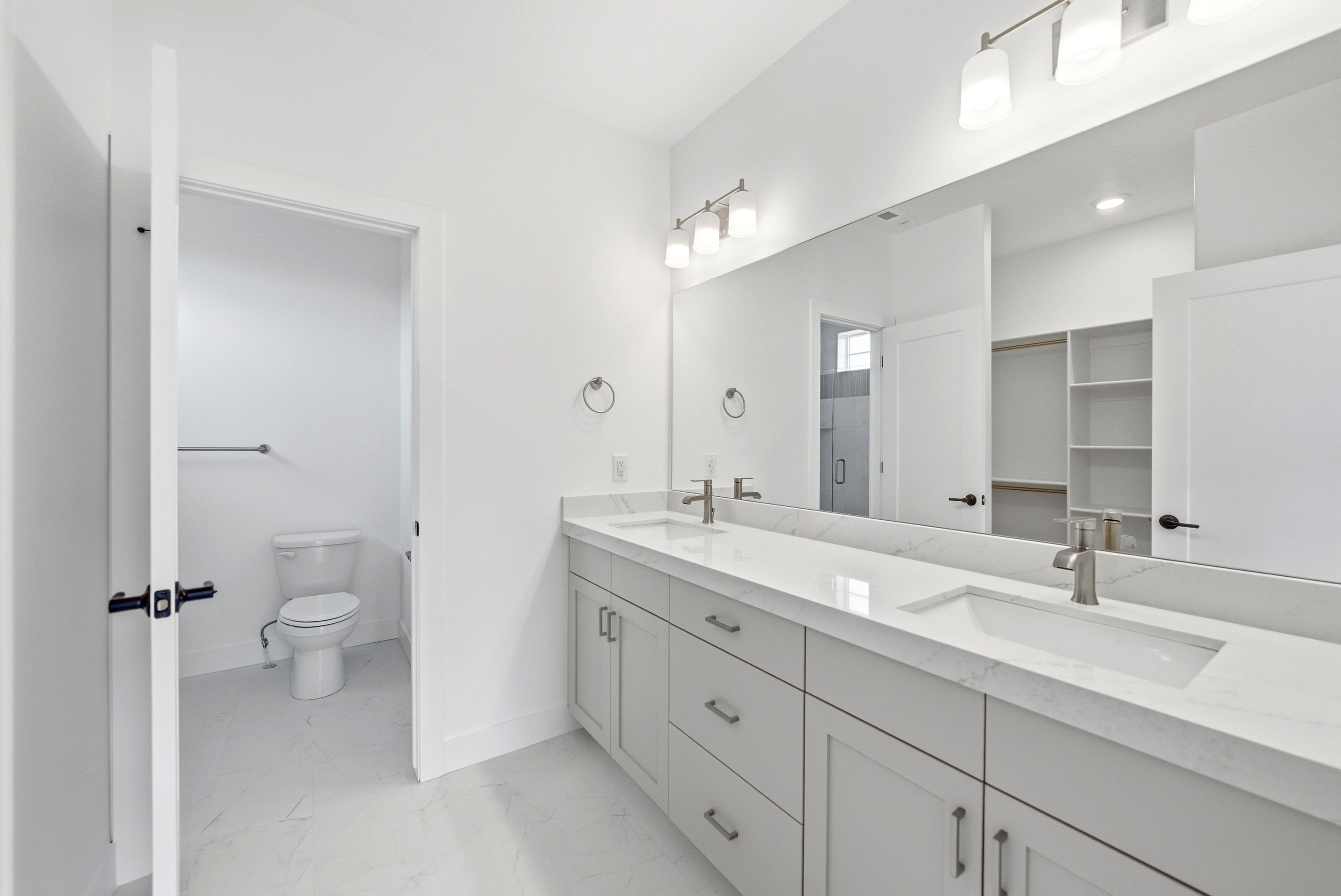 Double vanity featuring undermount sinks, stone countertops, and brushed nickel fixtures
