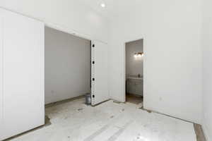 Unfurnished bedroom with baseboards and ensuite bath